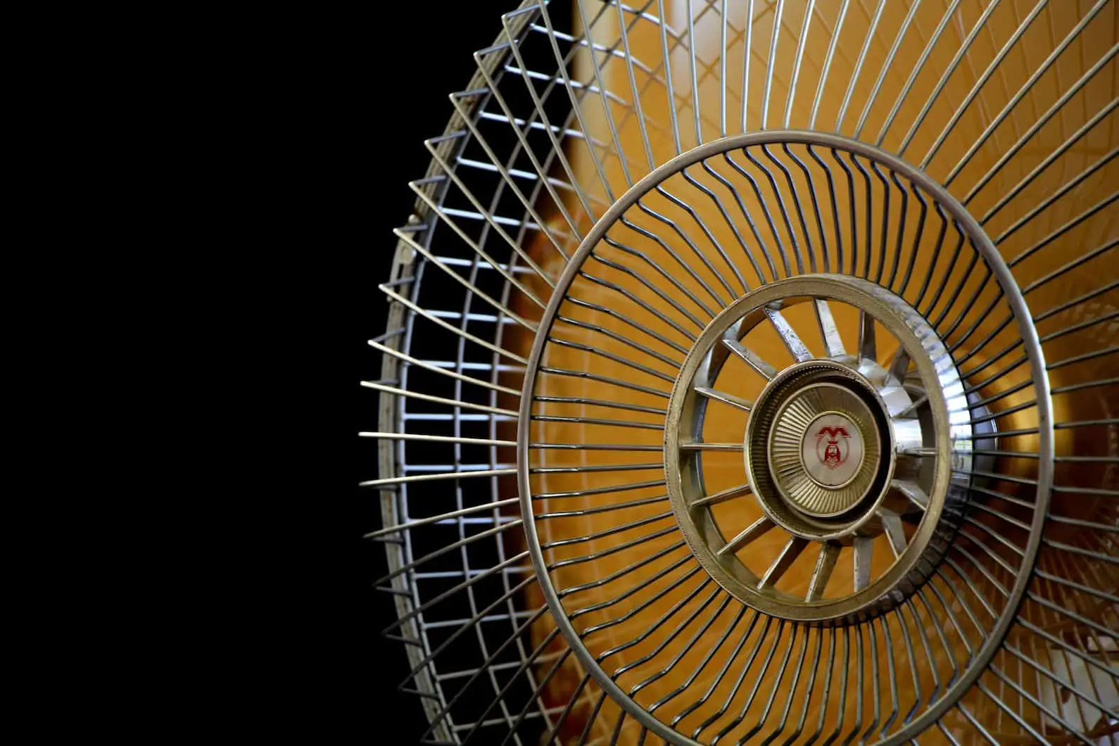 Close-up Photography of Gray Stainless Steel Fan Turned on Surrounded by Dark Background
